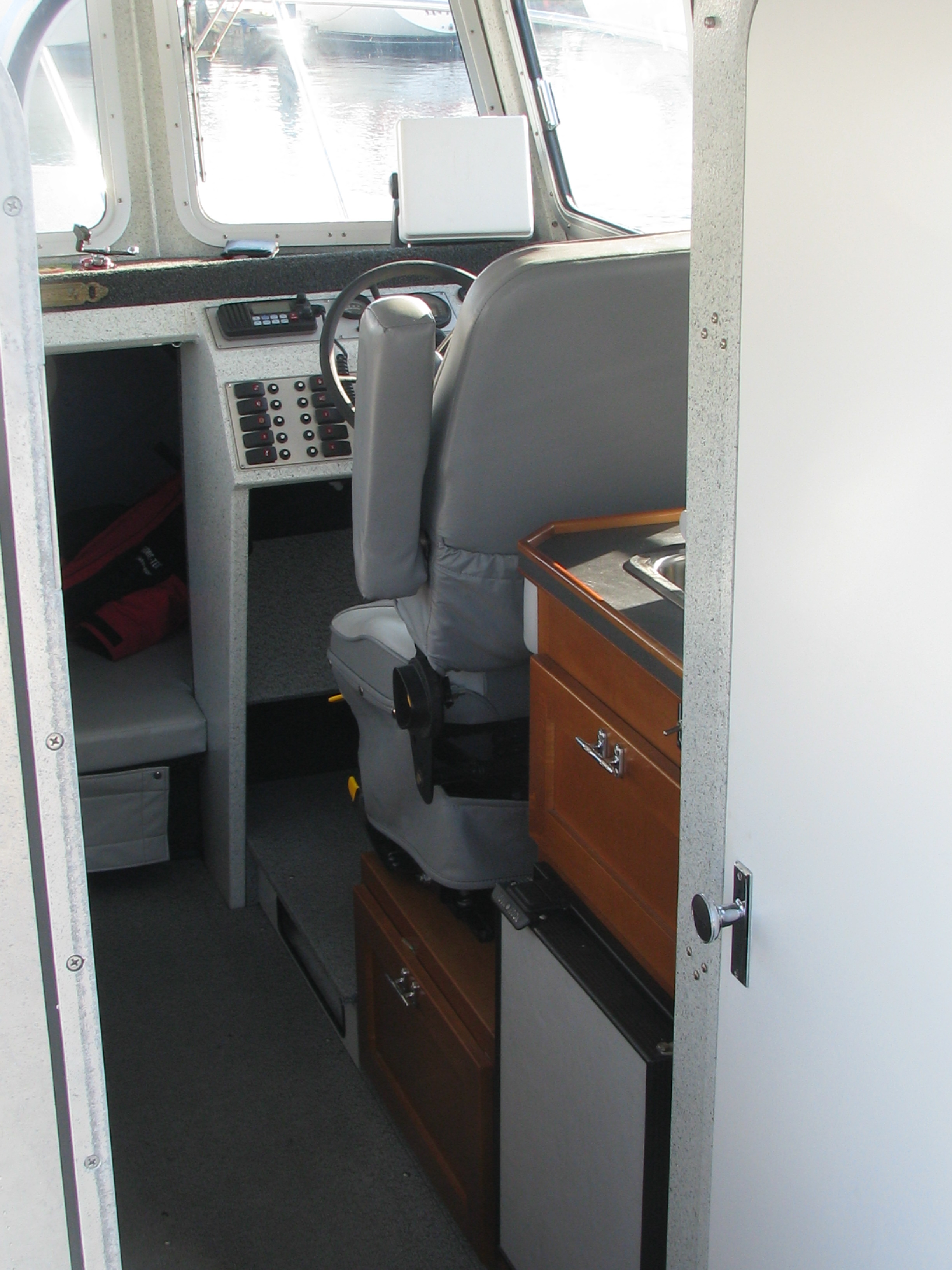 Interior of Highliner Charters' 26-foot Harbercraft Kingfisher fishing boat, starboard side cabin, featuring the pilot's controls and navigation system.